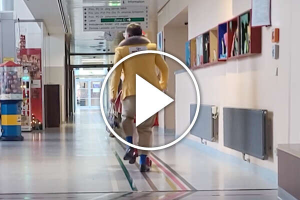 ROTE NASEN-Clowns im Gänsemarsch auf dem Flur eines Krankenhauses.