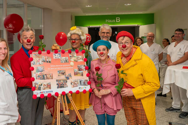 Mehrere Clowns der ROTE NASEN zu Besuch in einer medizinischen Einrichtung.
