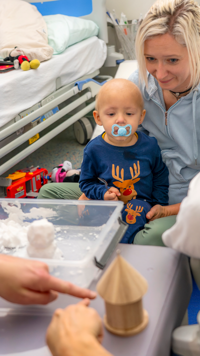 Levi beobachtet auf der Schoß seiner Mutter das Geschehen.