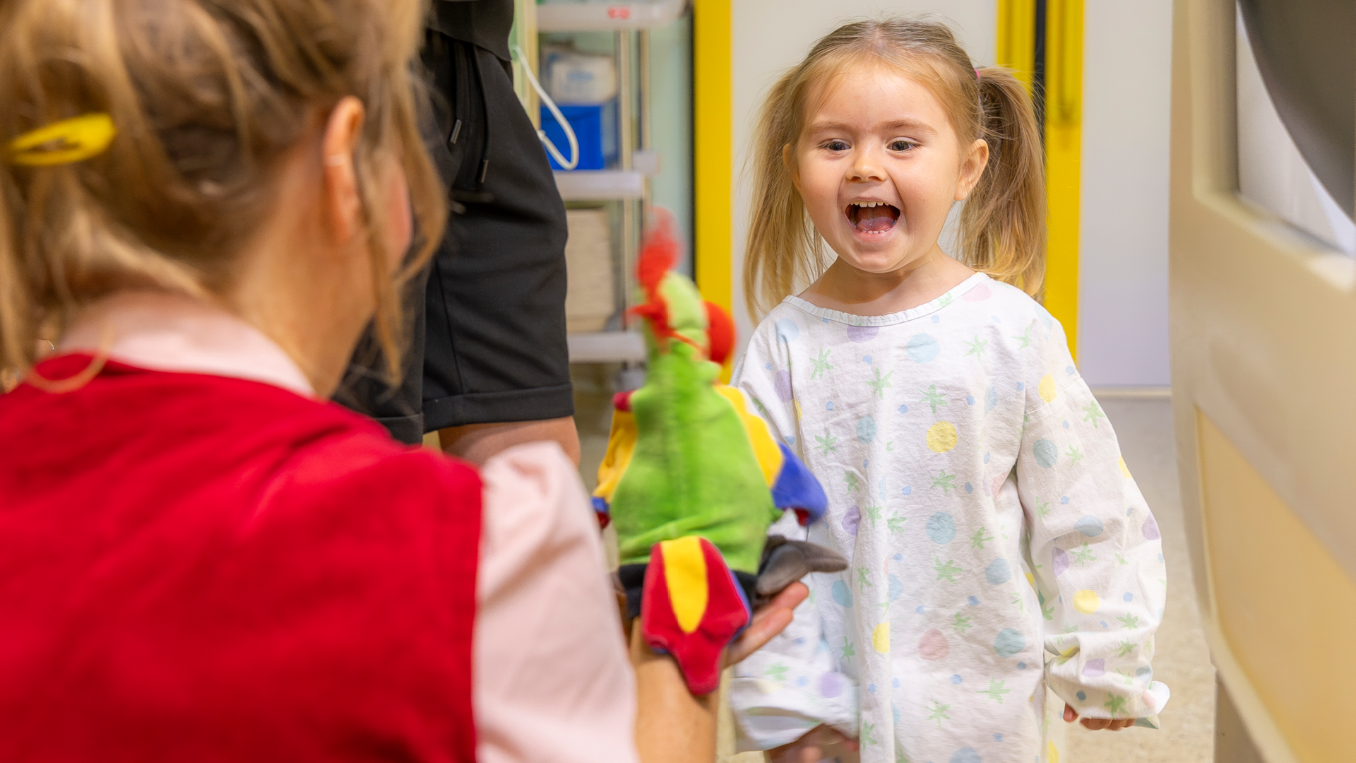 Ein kleines Mädchen, das lacht mit Clownin Lilo und ihrer Handpuppe.